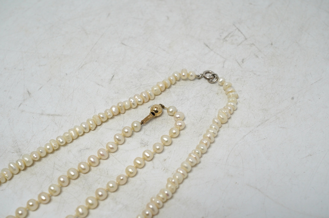 A single strand cultured pearl choker necklace, with 375 clasp, 38cm, together with a freshwater pearl necklace with 925 clasp. Condition - fair